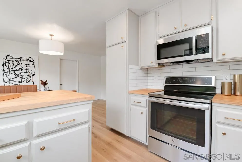 4635 Briar Ridge Road Oceanside, CA 92056 - Photo 3 of 23 a kitchen with stainless steel appliances granite countertop a stove microwave and sink