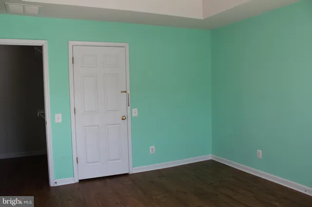 an empty room with wooden floor and closet
