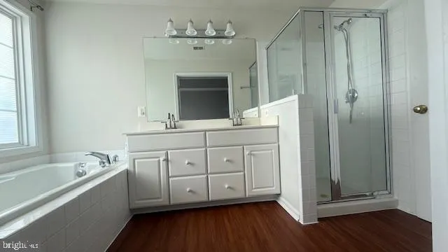 a spacious bathroom with a double vanity sink a mirror and a bathtub