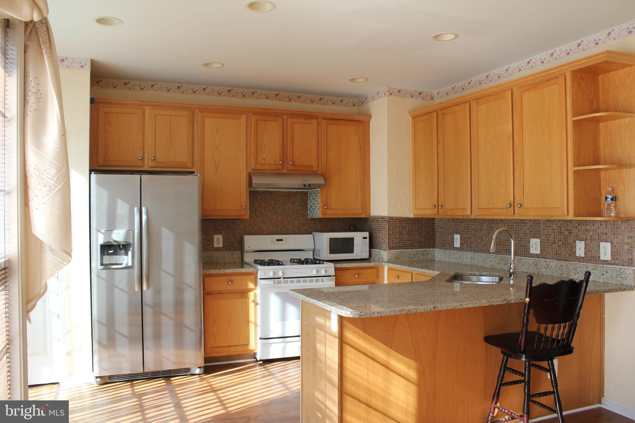13507 Stargazer Terrace Centreville, VA 20120 - Photo 2 of 25 a kitchen with stainless steel appliances granite countertop a refrigerator a stove a sink dishwasher and white cabinets with wooden floor