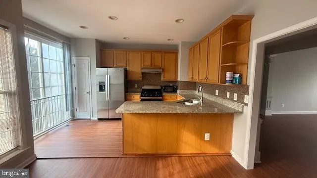 a kitchen with kitchen island a counter top space a sink a refrigerator and a window