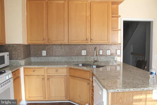 a kitchen with granite countertop a sink window and cabinets