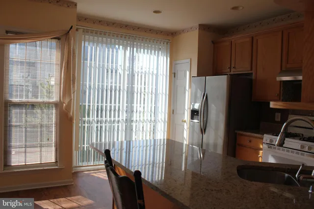 a kitchen with stainless steel appliances granite countertop a refrigerator and a sink