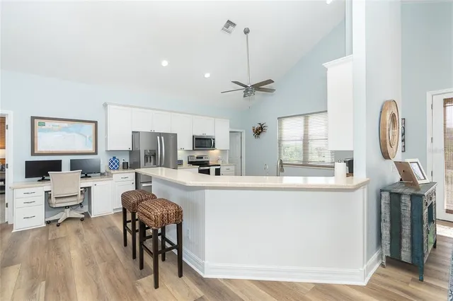 a kitchen with a sink cabinets and wooden floor