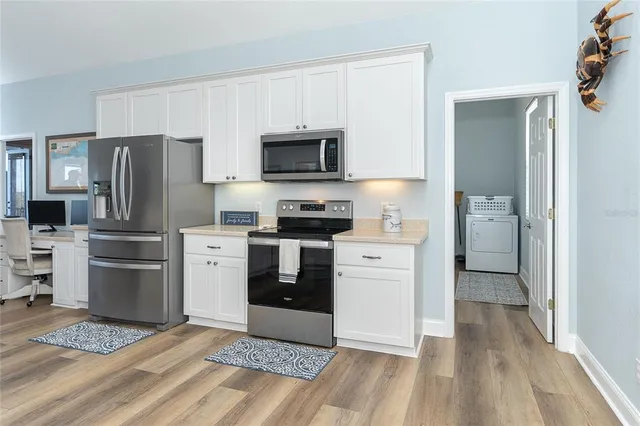 a room with a white cabinets and washer dryer