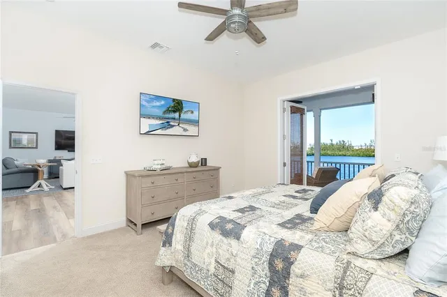 a bed sitting in a bedroom next to a window and a chandelier