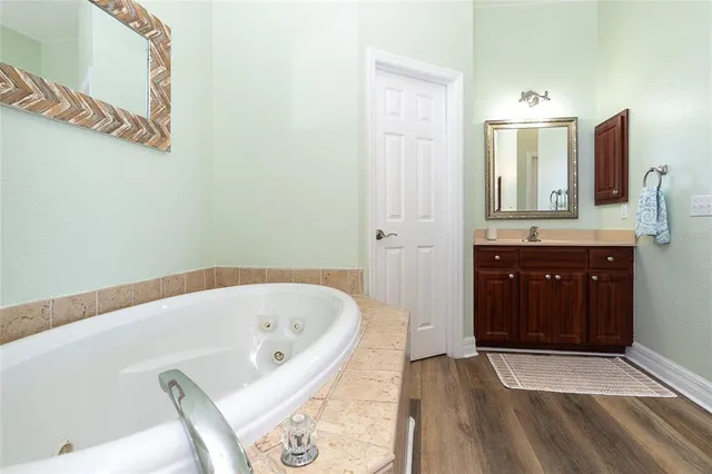 a spacious bedroom with a bed and a lamp