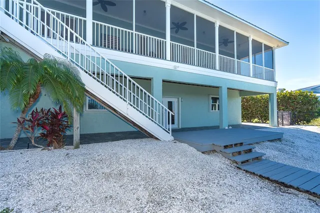 an aerial view of residential houses with outdoor space and ocean view