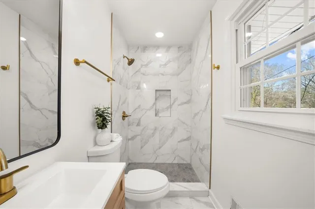 a bathroom with a sink a toilet and shower