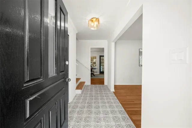 a view of a hallway with wooden floor and staircase
