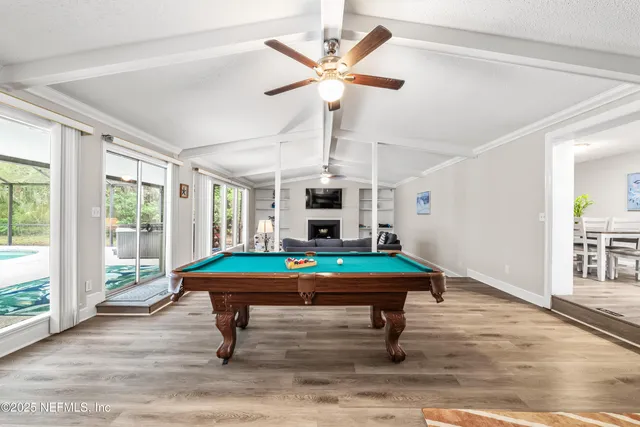 a room with pool table and windows