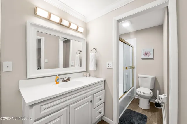 a bathroom with a sink a toilet and shower a mirror