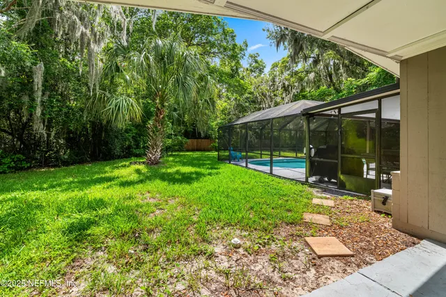 an aerial view of a house with a yard and large trees