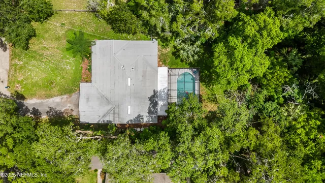 an aerial view of a house with pool and garden