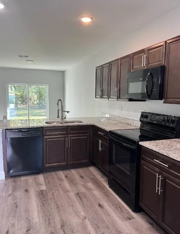 a kitchen with granite countertop a stove and a sink