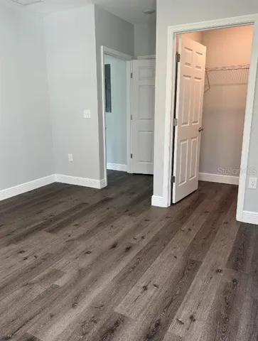 an empty room with wooden floor and entrance