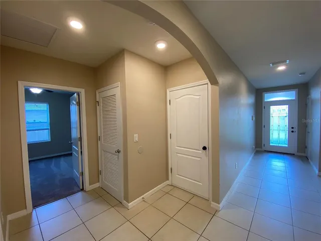 an empty room with mirror and a bathroom