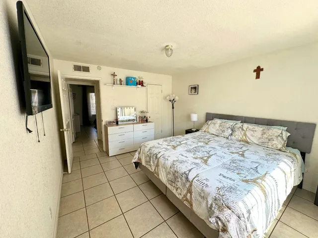 a bedroom with a bed and a refrigerator