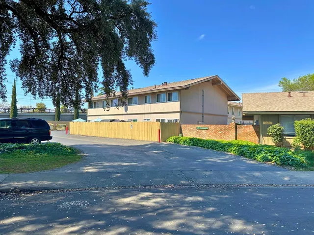 a view of a house with backyard and a tree