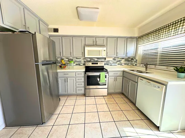 a kitchen with stainless steel appliances a stove a sink and a refrigerator