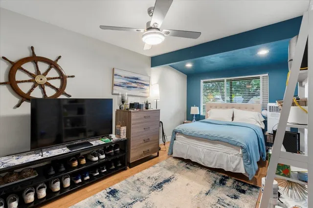 a bedroom with a bed and a flat tv screen on dresser