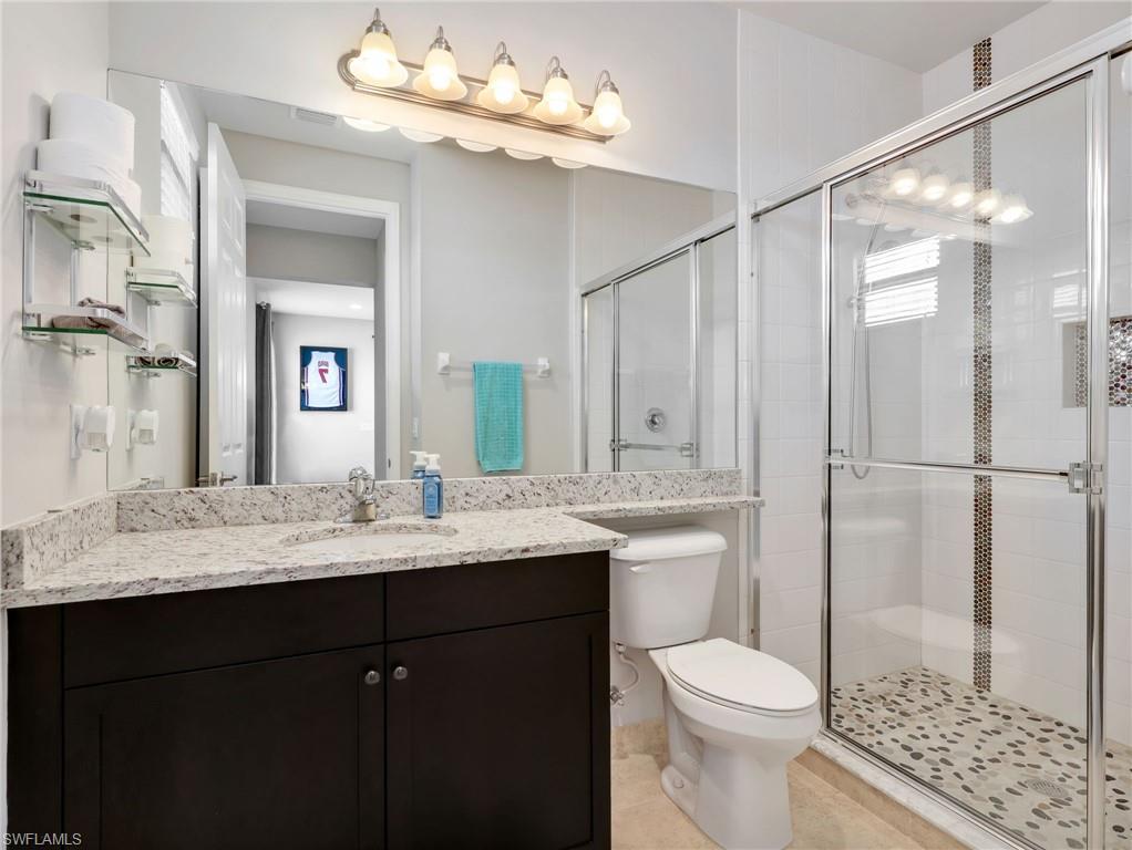 2756 Crystal Way Naples, FL 34119 - Photo 33 of 50 a bathroom with a sink vanity granite toilet and a mirror
