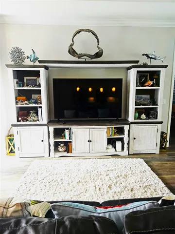 a kitchen with stainless steel appliances a stove a refrigerator a sink a dining table and chairs with wooden floor