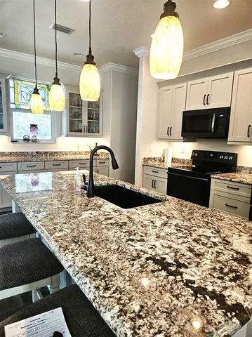 a kitchen with stainless steel appliances kitchen island granite countertop a sink stove and refrigerator