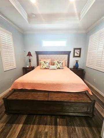 a bedroom with a large bed and a flat tv screen on dresser