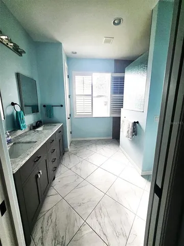 a bathroom with a sink double vanity granite and a mirror
