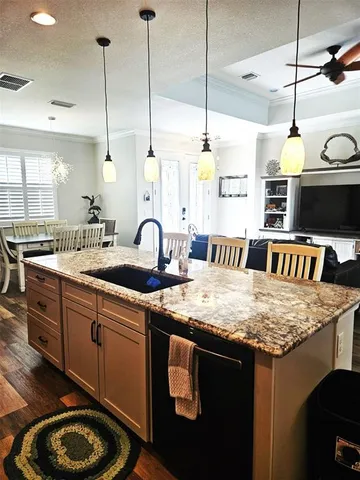 a kitchen with stainless steel appliances granite countertop a sink a stove and a wooden floors