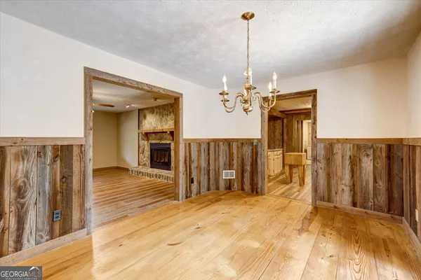 a view of a room with wooden floor kitchen and windows