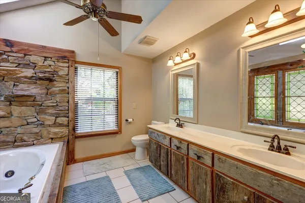 a view of a bathroom with a tub sink and mirror