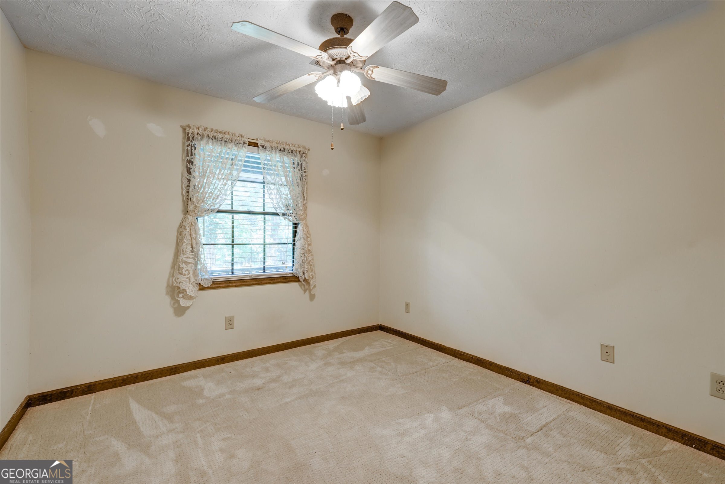 424 Hampton Road Hampton, GA 30228 - Photo 20 of 44 an empty room with a window and a fan