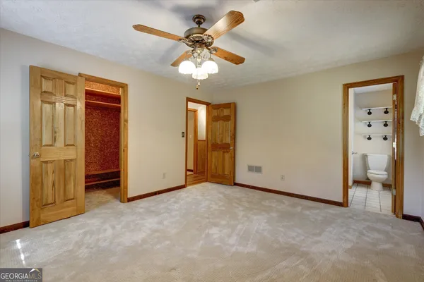 an empty room with fan and windows