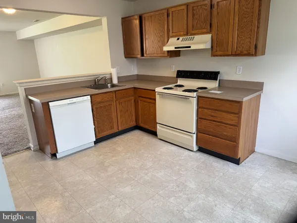 a kitchen with cabinets appliances a sink and a window