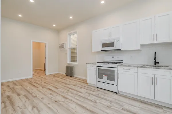 a kitchen with granite countertop white cabinets and stainless steel appliances