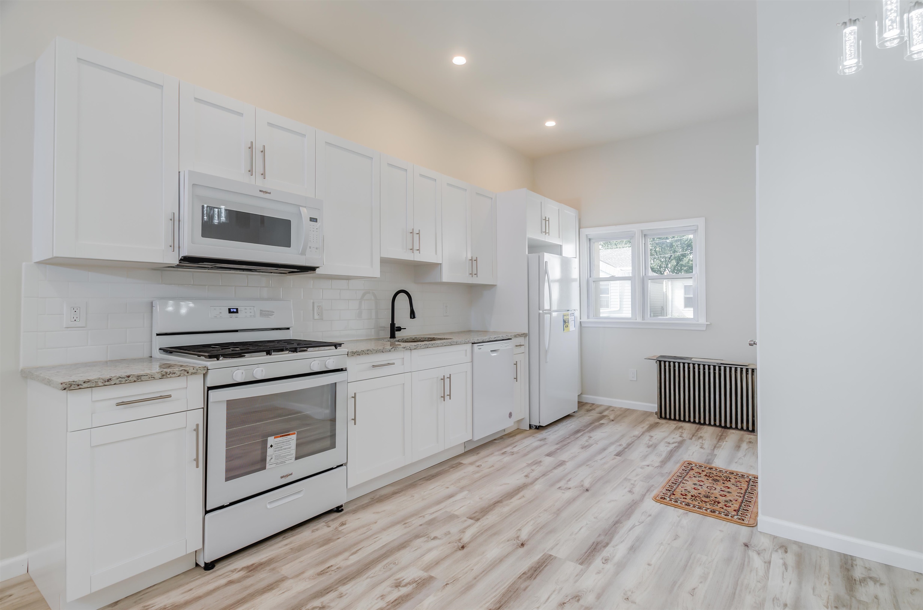 419 22nd Street, Unit 3 Union City, NJ 07087 - Photo 6 of 11 a kitchen with stainless steel appliances granite countertop a stove a sink and a microwave