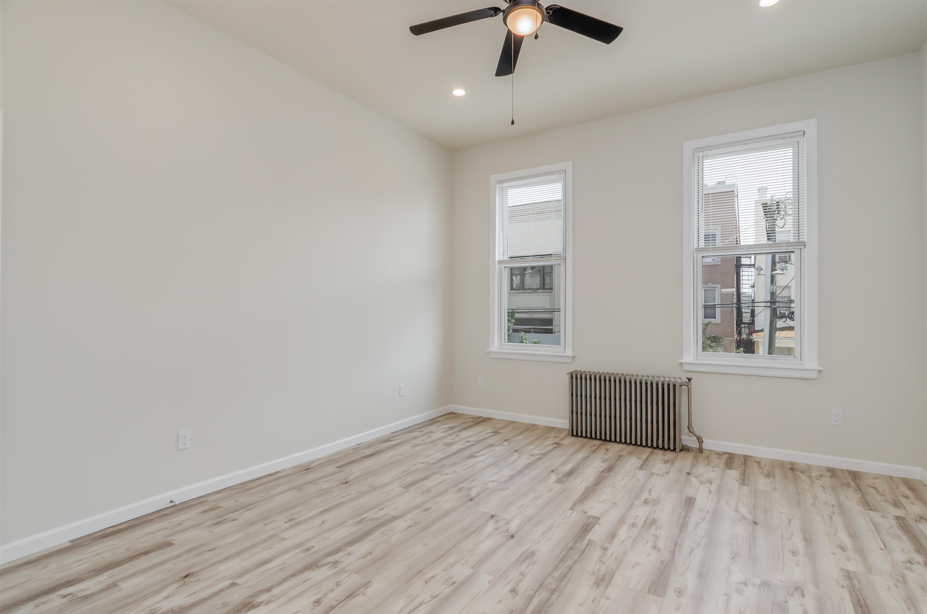 419 22nd Street, Unit 3 Union City, NJ 07087 - Photo 9 of 11 an empty room with wooden floor chandelier fan and windows