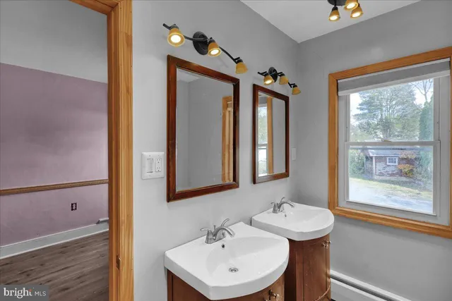 a bathroom with a sink a mirror and a window