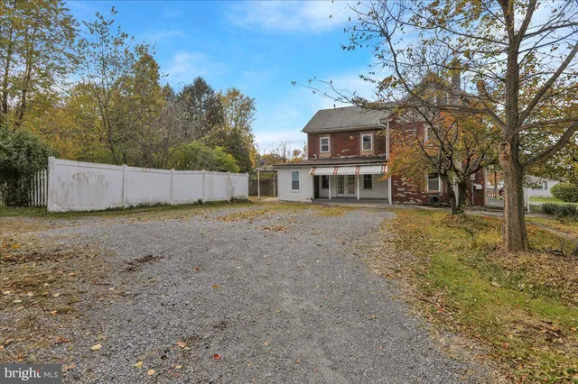 a view of a house with a yard and large trees