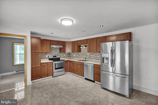 a kitchen with stainless steel appliances granite countertop a refrigerator oven a sink and dishwasher