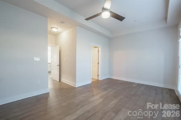 an empty room with wooden floor and ceiling fan