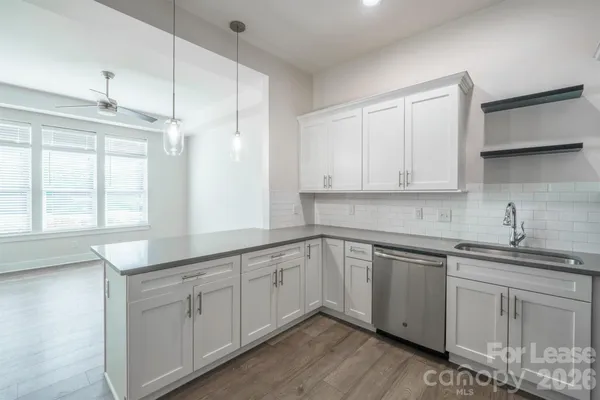a kitchen with white cabinets sink and window