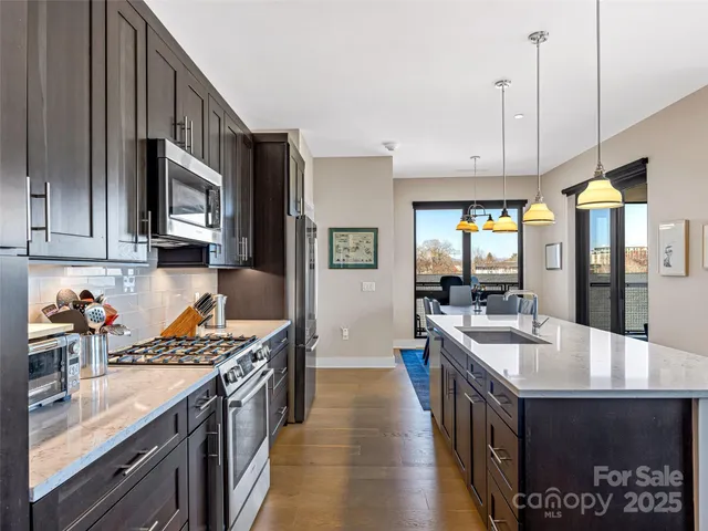 a kitchen with stainless steel appliances granite countertop a sink stove and refrigerator