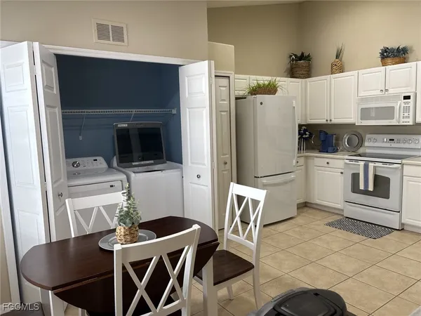 a kitchen with stainless steel appliances a stove a microwave a dining table and chairs
