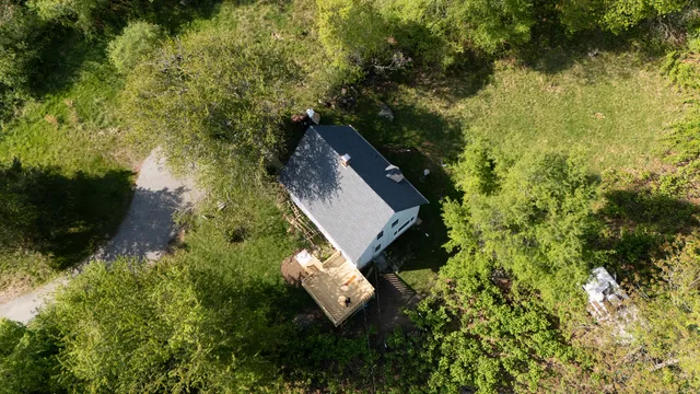 an aerial view of a house with a yard basket ball court and outdoor seating