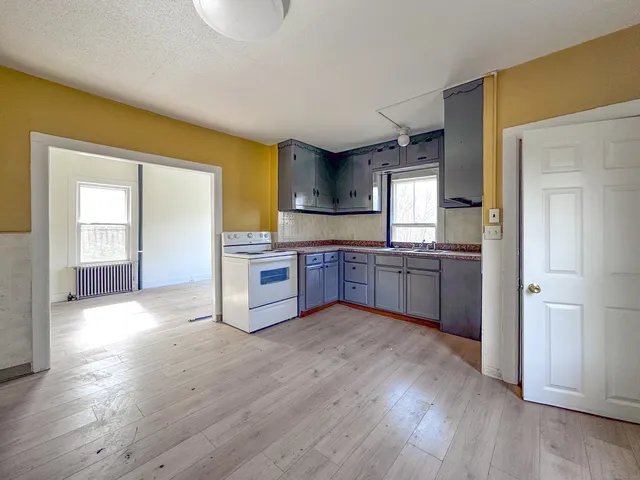 a large kitchen with cabinets and wooden floor