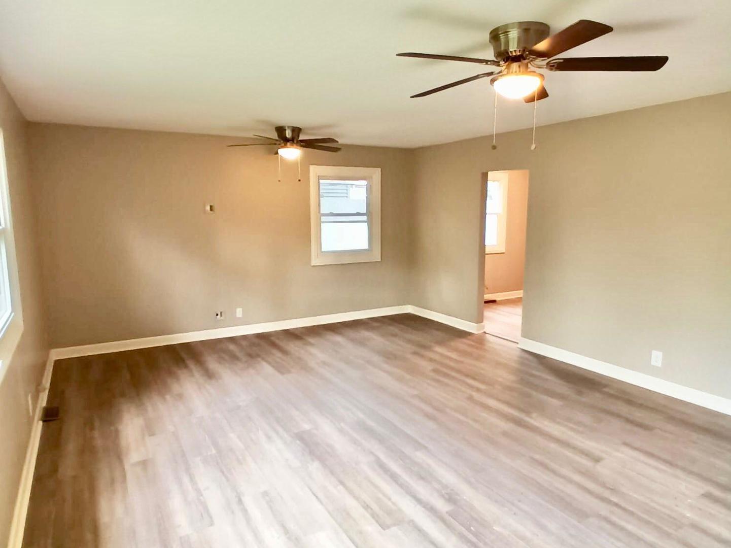 117 Kingston Road Bolingbrook, IL 60440 - Photo 11 of 24 an empty room with wooden floor fan and windows