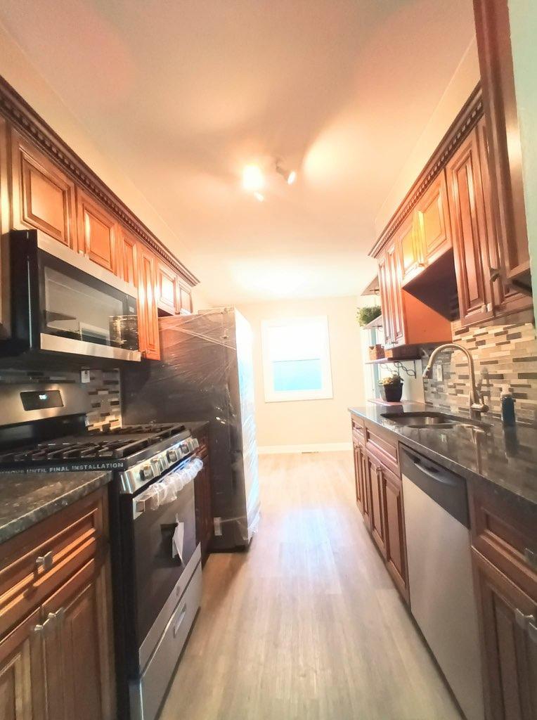 117 Kingston Road Bolingbrook, IL 60440 - Photo 2 of 24 a kitchen with stainless steel appliances granite countertop a stove a sink and a microwave